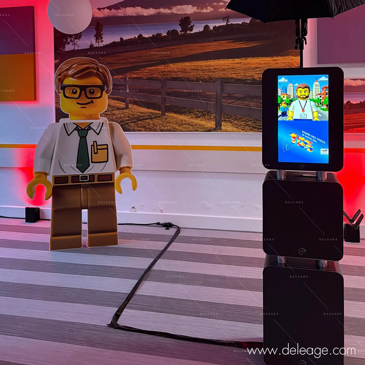 3-silhouette-lego-personnalisee-evenement-corporate Personnage LEGO géant découpé à la forme à côté d'une borne photo.