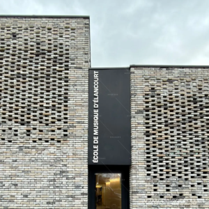 Zoom sur l'installation du panneau vertical entre deux pans de murs en briques.